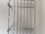 a picture of a metal basket on a white wall