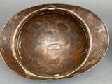 pair of antique brass ashtrays on a grey background