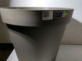 a gray planter sitting on a table with a tag on it