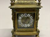 une horloge en or posée sur une surface blanche