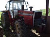 a red tractor that is parked in the shade