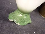 a green vase sitting on the floor next to a gold vase