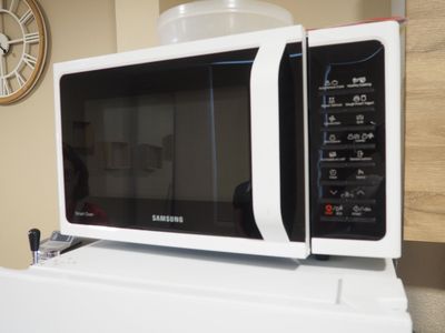 un micro-ondes posé sur un réfrigérateur