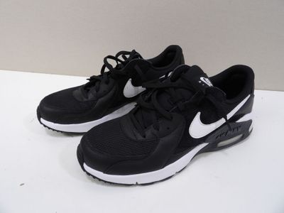 chaussures de course Nike Air Max noires et blanches posées sur une surface blanche