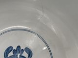 a blue and white bowl with a flower design on it