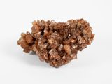 un amas de cristaux bruns sur une surface blanche