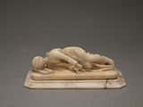 carved ivory figurine of a woman lying on a marble base