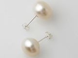 une paire de boucles d'oreilles en perles posées sur une surface blanche