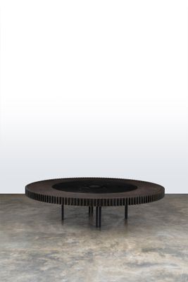 une photo d'une table basse ronde dans une pièce au sol en béton