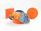 une boîte orange avec une écharpe bleue et orange et un bonnet bleu et orange
