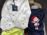 several children ' s clothing items are sitting on a cardboard box