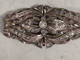 a close up of a silver brooch with diamonds on it