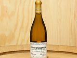 une bouteille de vin posée sur un tonneau en bois