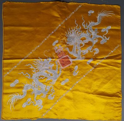 une soie jaune brodée d'un dragon et sur laquelle figure un dragon