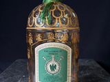 an old bottle of liquor sitting on top of a marble counter