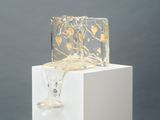 un vase en verre posé sur un socle blanc