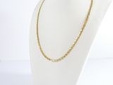 a gold chain necklace on a mannequin head