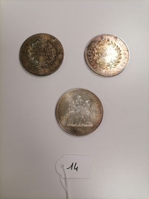 three silver coins are on display in a glass case