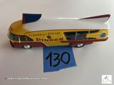 un petit bus jouet jaune et rouge posé sur une table blanche