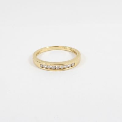 a yellow gold ring with five diamonds on a white background