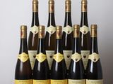 bottles of wine are lined up on a table in front of a white wall