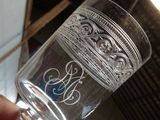 a person holding a glass with a monogram on it