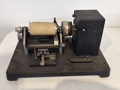 une machine d'un ancien modèle sur laquelle est posé un rouleau de papier
