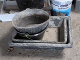 a bucket and a bowl sitting on the ground next to buckets