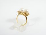 a close up of a gold ring with two pearls on it
