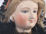 a close up of a doll with a teddy bear