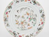 une image représentant une assiette blanche ornée de fleurs et d'oiseaux colorés