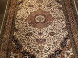 un tapis oriental exposé dans une pièce au sol marron