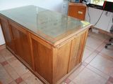 a desk with a glass top in the corner of a room