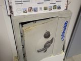 a safe box with a poster on it in the corner of a room