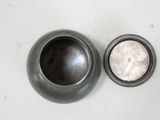a silver bowl and a black bowl on a white table