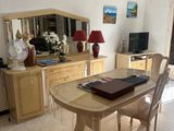 une salle à manger avec une table, des chaises et une télévision