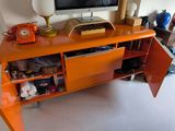 an orange desk with a computer on top of it