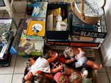a pile of dolls and books on the floor