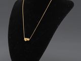 un mannequin noir portant un collier en or