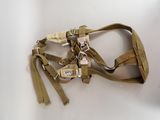 a tan harness on a white table with a key