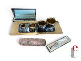 trois tasses et une boîte posées sur une surface blanche