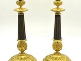 deux bougeoirs noirs et dorés sur fond blanc