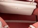 the inside of a pink purse with a white handle