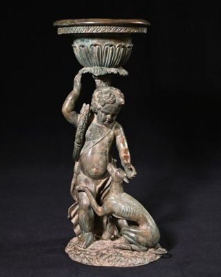 statue en bronze d'un homme avec un bol sur la tête tenant un chien