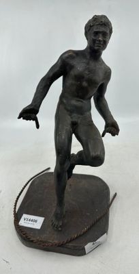statue en bronze représentant un homme courant sur une corde posée sur une surface blanche