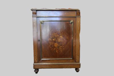 une armoire en bois dont la porte est ornée d'un motif floral