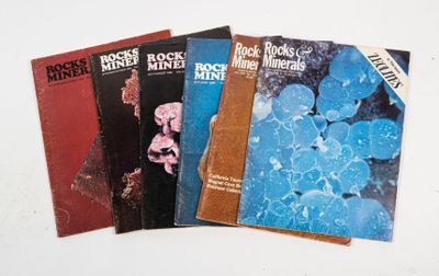 three books on a white table with blue flowers on them