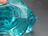 un gros plan d'une personne tenant un objet en verre bleu