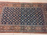 un tapis oriental posé à même le sol dans une pièce carrelée