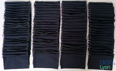 quatre paires de pantalons noirs sont alignées sur une surface blanche